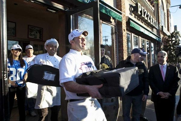 Vincenzo Corteo carries pizza pies to a sheriff's