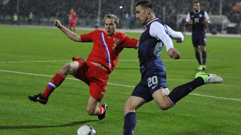 Russia's Aleksandr Anyukov, left, vies with USA's Geoff Cameron in...