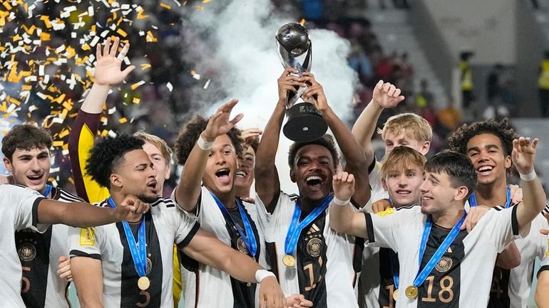 Team Germany celebrates on the podium with their trophy after...