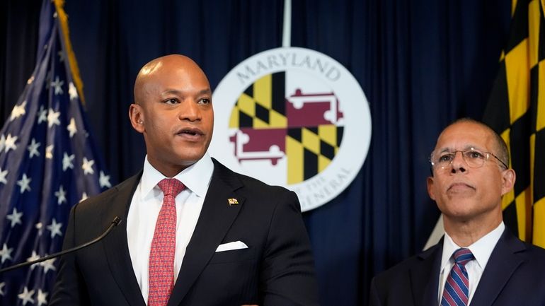 Maryland Gov. Wes Moore, left, flanked by Attorney General Anthony...