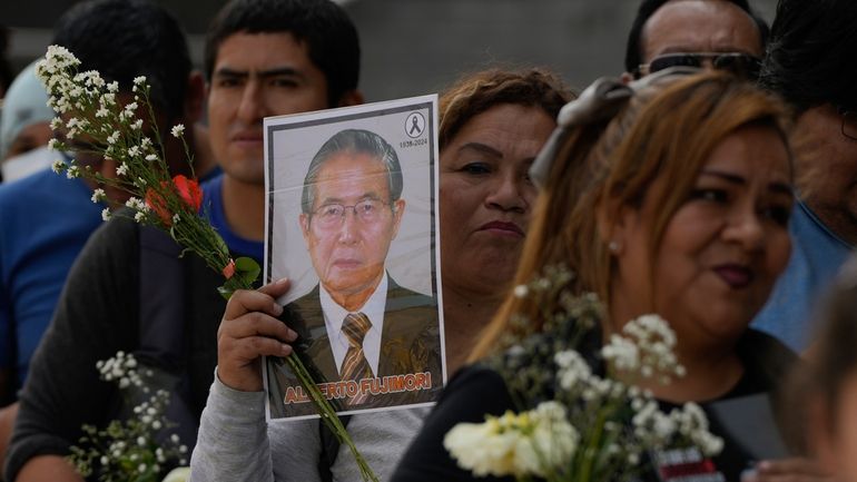 Supporters of former President Alberto Fujimori line up to pay...