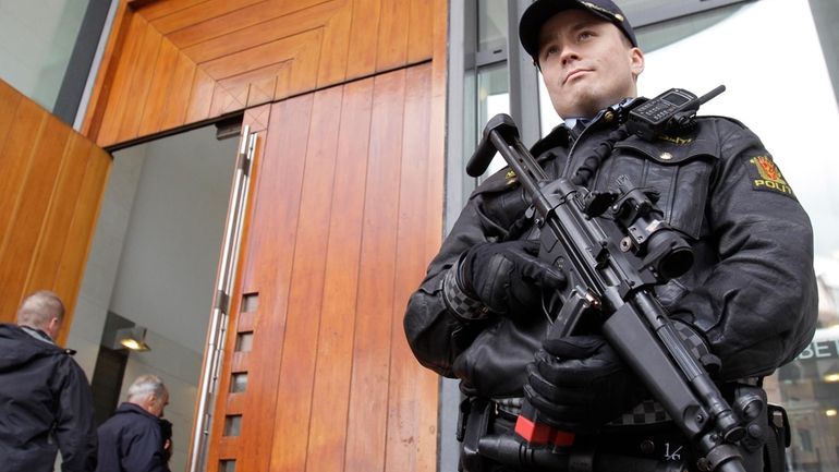 A police officer stands guard outside the entrance of the...