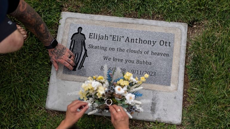 Mikayla Brown and her husband, Tyler, visit the grave of...