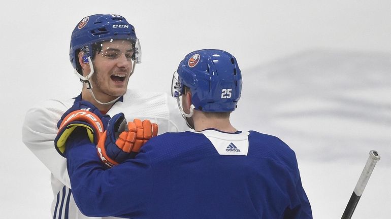 Mathew Barzal #13 of the Islanders, left, and teammate Devon...