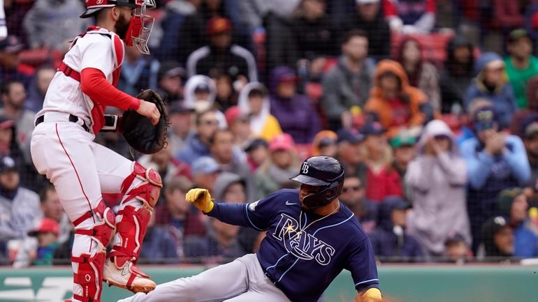 Tampa Bay Rays' Isaac Paredes, right, scores on a fielding...