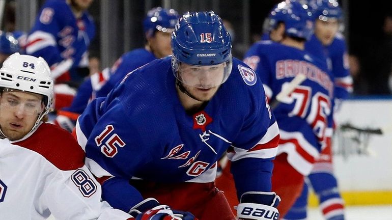 Julien Gauthier of the New York Rangers battles for the...