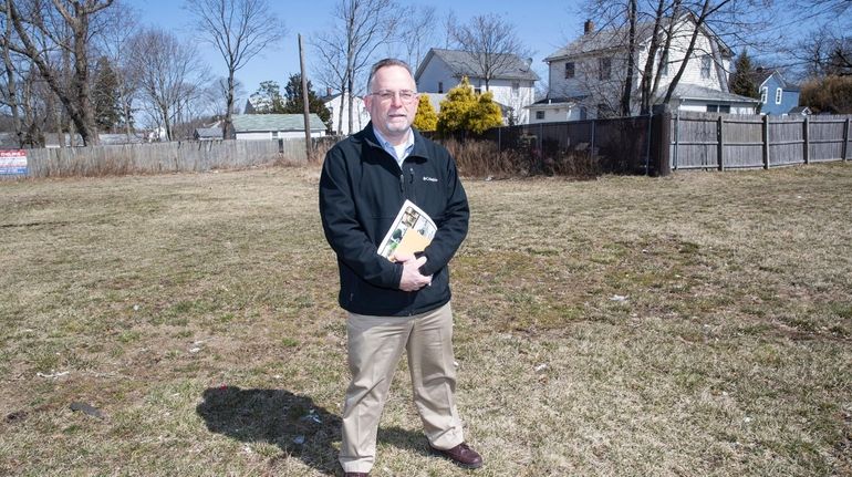 John Quatrale, a board member of Focus East Patchogue, stands...