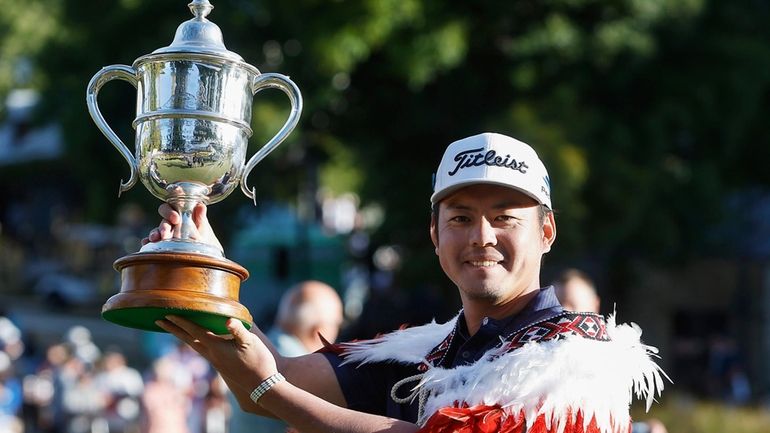 Japan's Takahiro Hataji holds his trophy aloft after winning the...