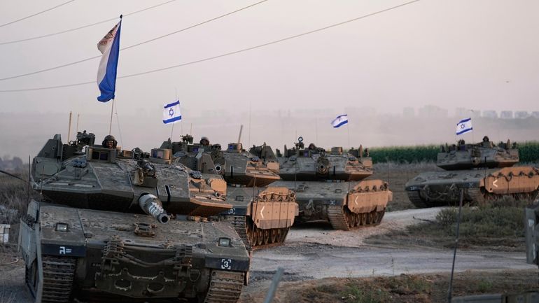 Israeli tanks head toward the border of the Gaza Strip in southern...