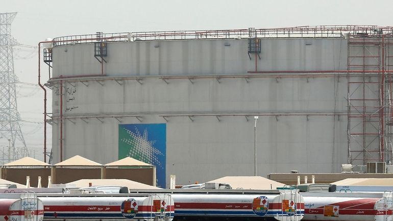 FILE - Fuel trucks line up in front of storage...