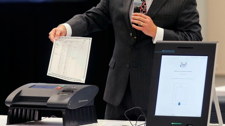 A Smartmatic representative demonstrates his company's system, which has scanners...