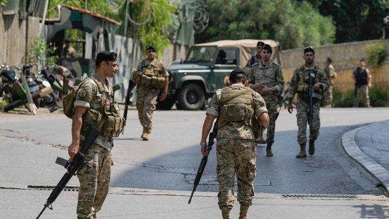 Lebanese security stand guard on a road that leads to...