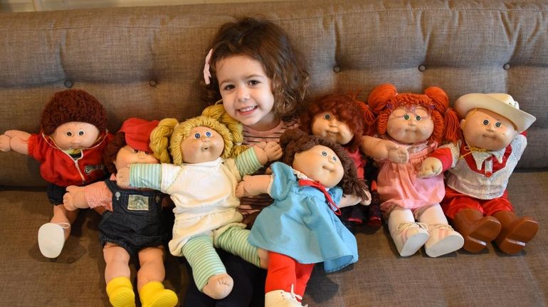 Casey O'Hara, 3, cuddles with Cabbage Patch Kids dolls that...