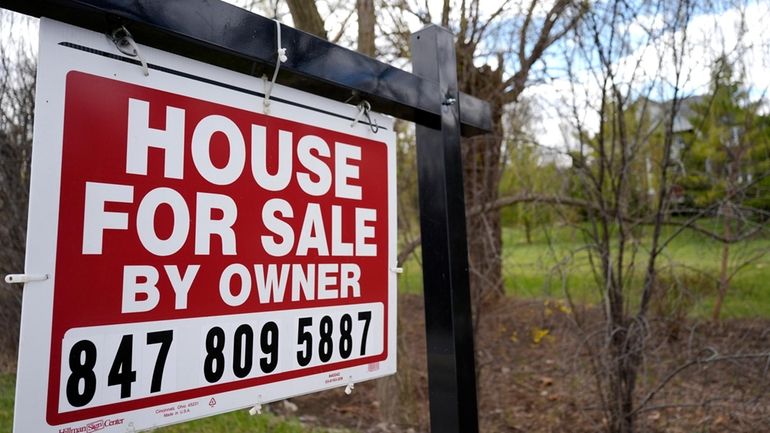 A sign announcing a house for sale is displayed in...