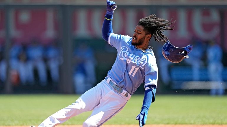 Kansas City Royals' Maikel Garcia slides into second after hitting...