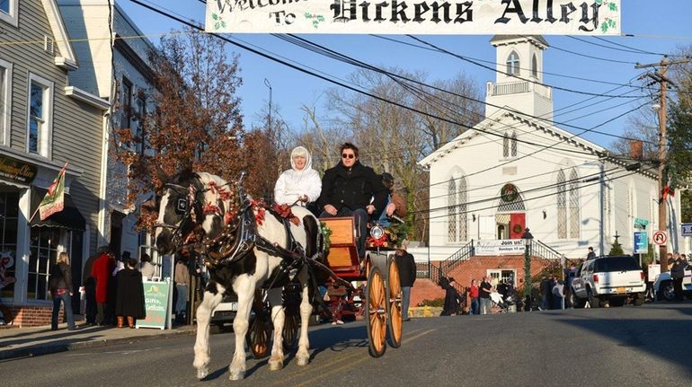 Visitors to the Charles Dickens Festival ride on a horse-drawn...