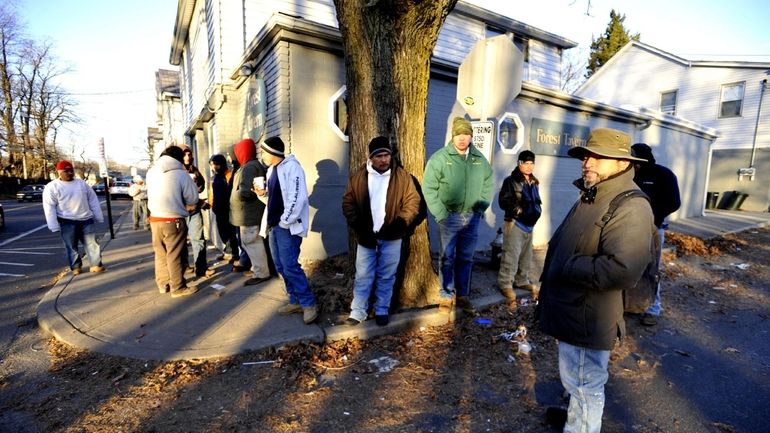 Day laborers gather on the sidewalk hoping to find work....