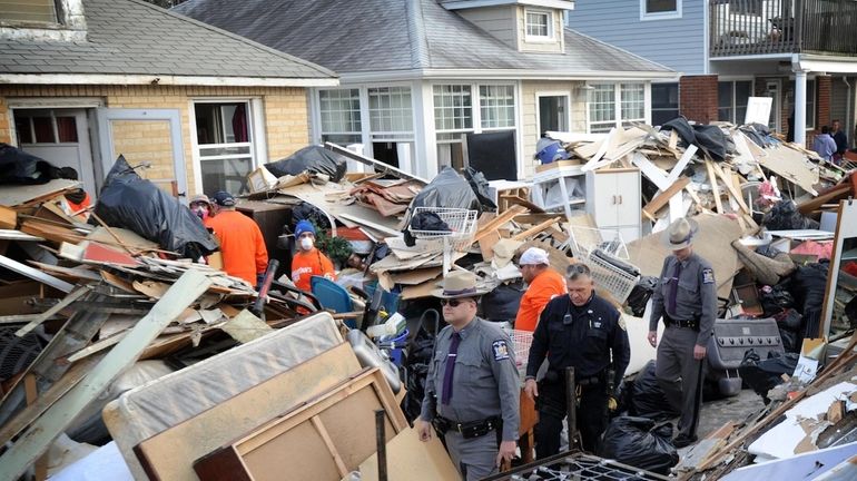 Debris is piled across Michigan Street in Long Beach as...