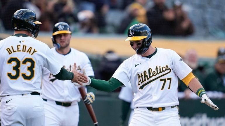 Oakland Athletics' Brett Harris (77) celebrates with JJ Bleday (33)...