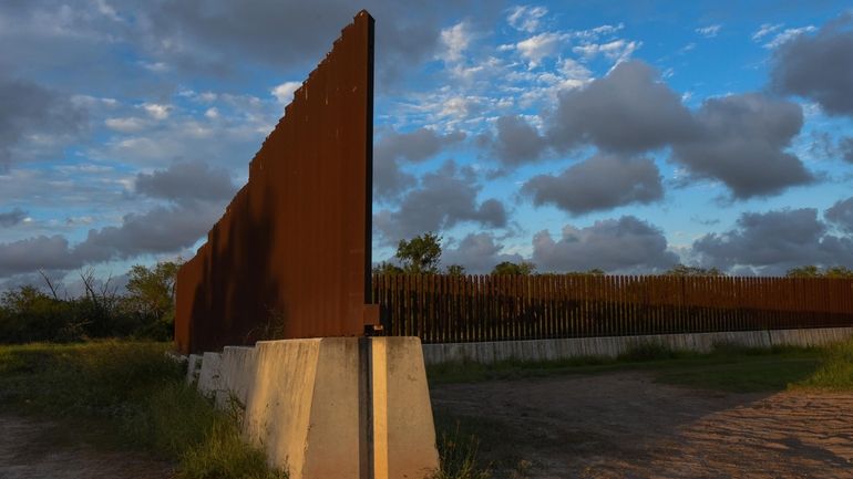 Dusk begins to fall at a section of border fence...