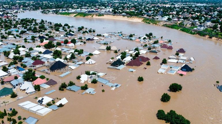 Houses are partially submerged following a dam collapse in Maiduguri,...