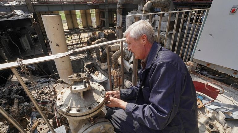 A worker repairs damaged thermal power plant, one of the...