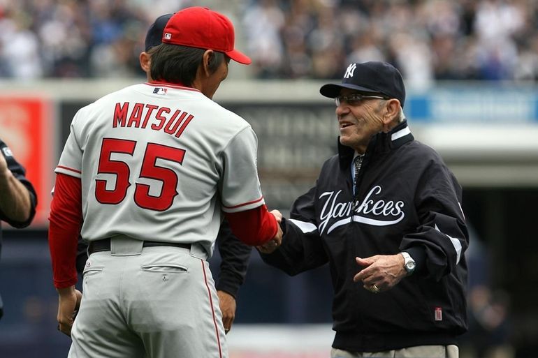 New York Yankees catcher Jorge Posada, left, walks off the field with  former Yankees catcher Yogi Berra after ceremonies at Yankee Stadium in New  York on Sunday, Sept. 21, 2008. The Yankees