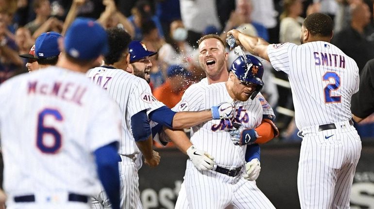 Mets players mob Brandon Drury after his game-winning walk-off single...