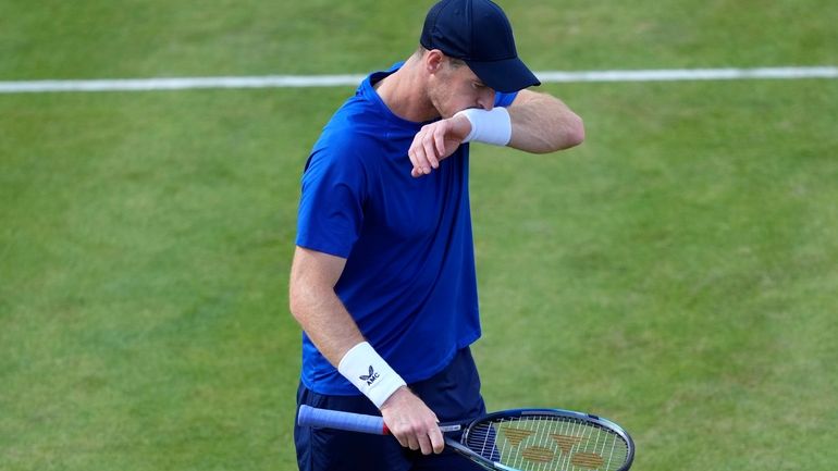 Andy Murray of Britain wipes his face as he is...