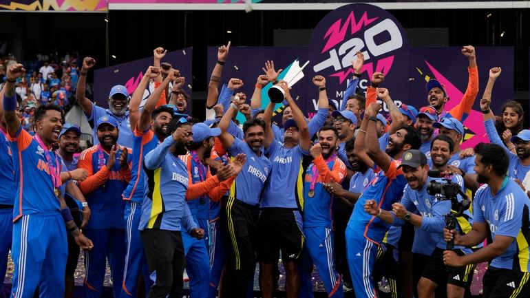 India's head coach Rahul Dravid, center, and players celebrate with...