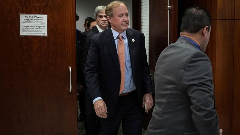 Texas Attorney General Ken Paxton, center, leaves the 185th District...