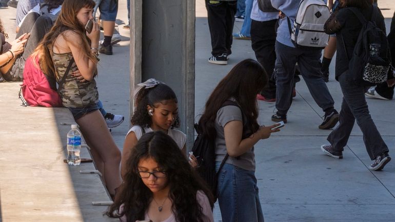 Students use their cellphones as they leave for the day...