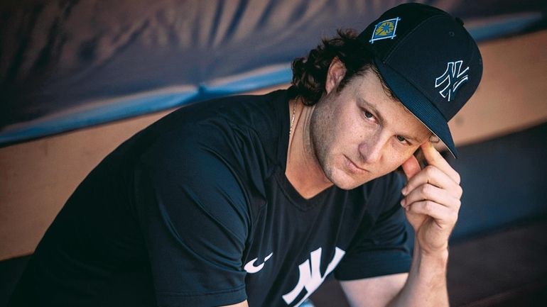 Yankees pitcher Gerrit Cole sits in the dugout during spring training at...