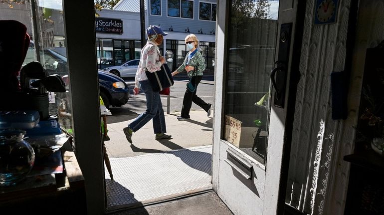 People walk Thursday past Santoli Radio and TV Service, along...