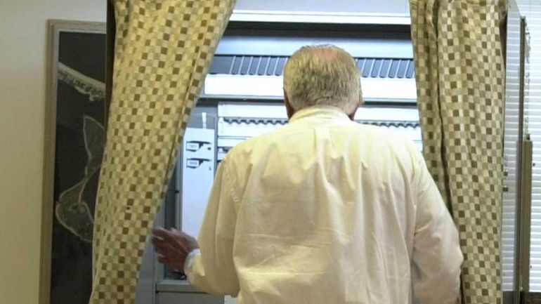 A voter entering a voting booth at Asharoken Village Hall.