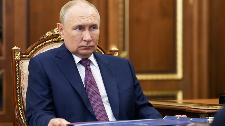 Russian President Vladimir Putin listens to Astrakhan region governor Igor...