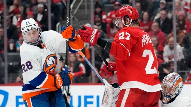 Red Wings center Michael Rasmussen and Islanders defenseman Alexander Romanov play...