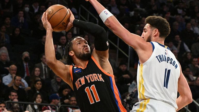 Knicks guard Jalen Brunson is defended by Golden State guard...