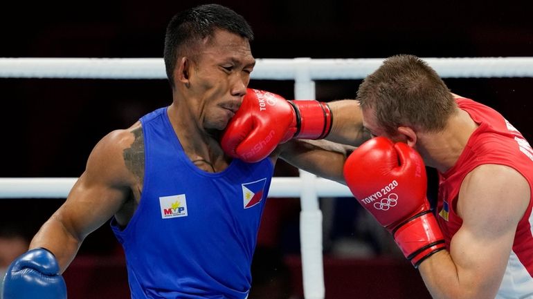 Philippine's Eumir Marcial, left, is punched by Ukraine's Oleksandr Khyzhniak...