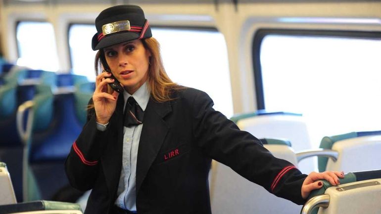 LIRR Conductor June Dicarlo using her cell phone on the...