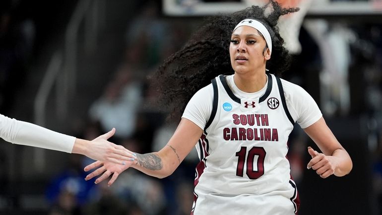 South Carolina center Kamilla Cardoso (10) gets a high five...