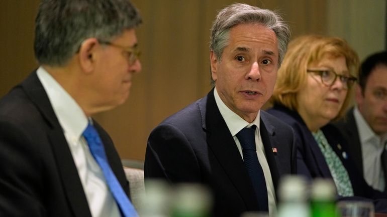 U.S. Secretary of State Antony Blinken, center, sits across the...