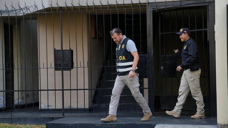 Police officers leave the home of Nicanor Boluarte, the brother...