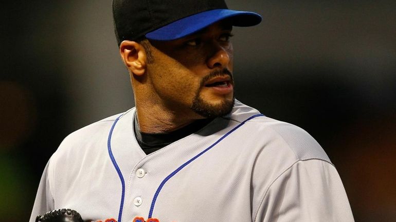 Johan Santana #57 of the New York Mets walks back...