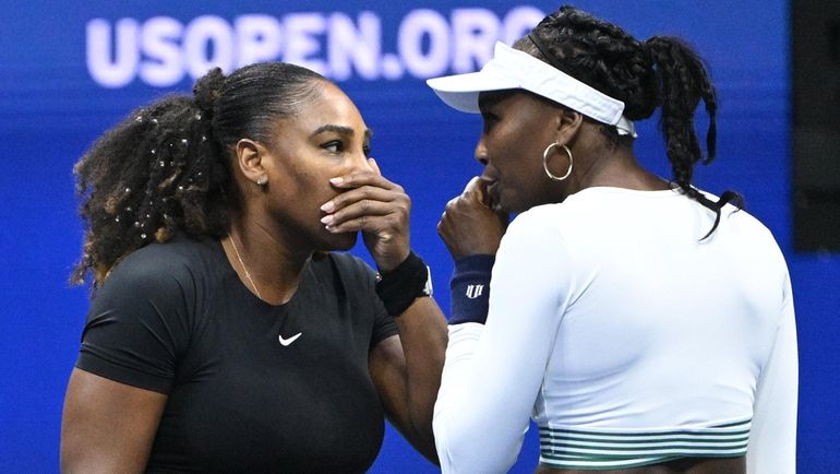 Serena Williams and Venus Williams compete in a doubles match...