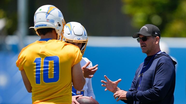 Los Angeles Chargers head coach Jim Harbaugh, right, speaks with...