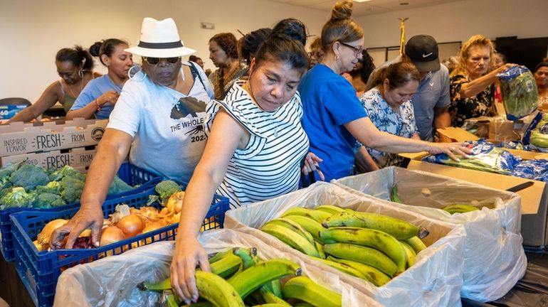 A crowd checks out the produce Friday at the farmers...