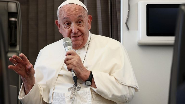 Pope Francis holds a news conference aboard the papal plane...