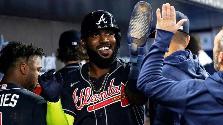 Atlanta Braves Marcell Ozuna (20) is congratulates by his teammates...