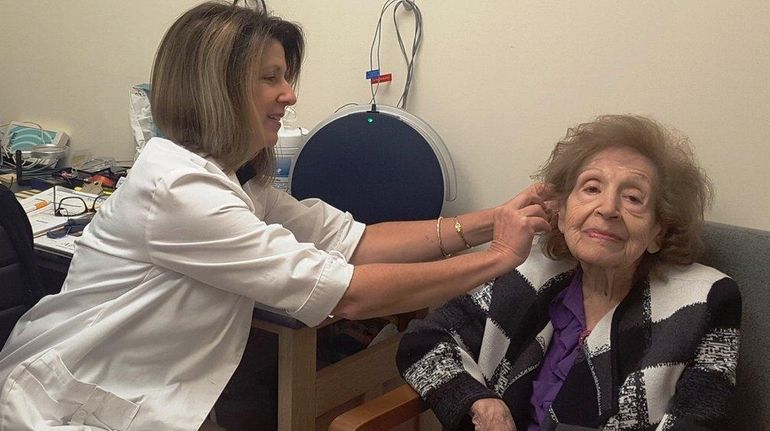 Sally Lepis of Selden gets hearing aids from audiologist Paula...